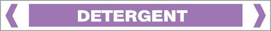 A rectangular sign with a purple background displays "ACID / ALKALI - DETERGENT" in bold white capital letters, with white arrows pointing inward on each side.