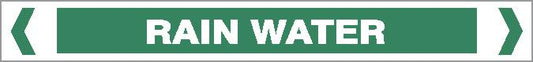 A green rectangular Pipe Marker – WATER – RAIN WATER sign displays "RAIN WATER" in bold white capitals, with white chevron symbols on both sides.